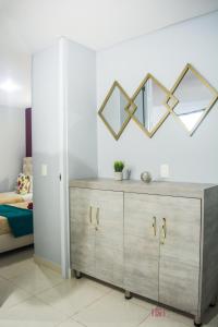 a bedroom with a wooden dresser with mirrors on the wall at Apartamento con parqueadero, piscinas y wifi a 5 min del parque del café in Montenegro