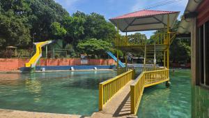 a water park with a slide in the water at La Joya de Opico in San Juan Opico