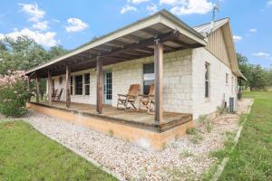 a house with a deck with two chairs on it at Pecan Farm Haus in Fredericksburg +45 photos