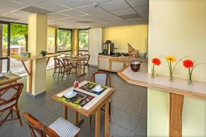 cocina y comedor con mesas y sillas en Hotel Eco - A75 en Banassac