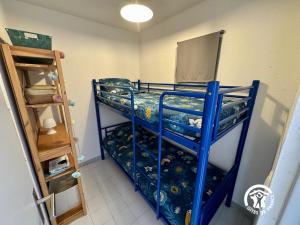 una piccola stanza con un letto a castello blu di Le grand bleu a Narbonne