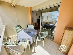 un balcone con tavolo e sedie su un balcone di Le grand bleu a Narbonne
