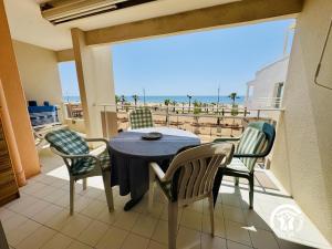 un tavolo e sedie su un balcone con vista sulla spiaggia di Le grand bleu a Narbonne
