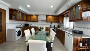 a kitchen with a glass table and white appliances at RIVABeach House in Lourinhã