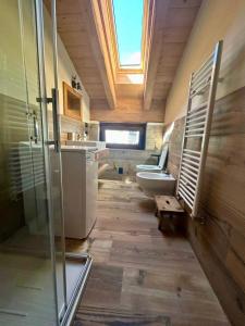 a bathroom with a toilet and a sink with a skylight at Méijòn Lo Brenlo in Courmayeur +12 photos