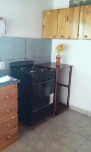 a kitchen with a black stove and a table at Marcelo Buja in Jardín América