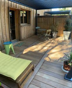 a wooden deck with a table and chairs on it at Les ptis chiffons in Lacanau +5 photos