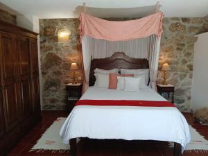 ein Schlafzimmer mit einem großen Bett mit Himmelbett in der Unterkunft Casas do Rio in Cossourado