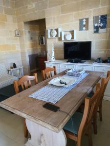 Una mesa de madera con sillas y una computadora encima. en MAGIA Salento, en San Pietro in Bevagna