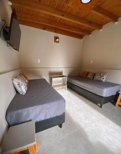 a bedroom with two beds and a tv in it at Cabañas Villa de Luján in San Rafael +44 photos