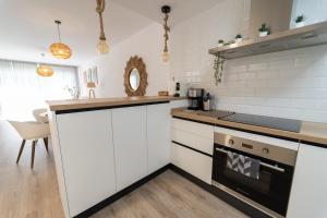a kitchen with white cabinets and a stove top oven at Apartment Casa del Sol in Gran Alacant