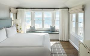 a bedroom with a large white bed and windows at Chatham Bars Inn in Chatham +37 photos