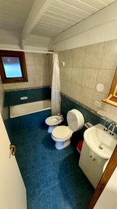 ein Badezimmer mit zwei Toiletten und einem Waschbecken in der Unterkunft Cabañas Los Cipreses- Pellín in San Martín de los Andes