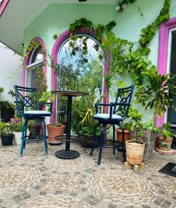 a patio with two chairs and a table and plants at The Quetzal in Cancún