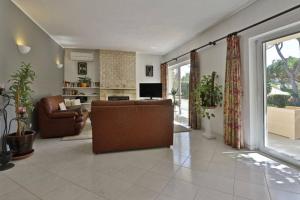 a living room with a couch and a television at Villa Quadradinhos 21Q 4 Bedroooms Private Pool Vale Do Lobo in Vale do Lobo