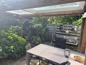a patio with a table and chairs under a pergola at Chalet op de veluwe in Putten