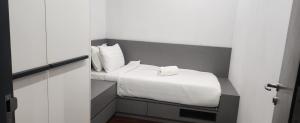 Un dormitorio con una cama con sábanas y almohadas blancas. en Sky Suites at Wyndham KLCC, en Kuala Lumpur