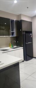 cocina con armarios en blanco y negro y nevera negra en Sky Suites at Wyndham KLCC, en Kuala Lumpur 4 fotos más