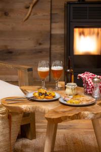 two glasses of beer and food on a wooden table at Cabanyes entre Valls in Vall de Bianya