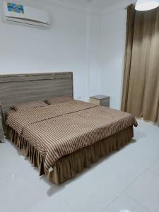 a bedroom with a bed with a brown comforter at رحاب السعاده rehab alsaadah apartment in Salalah