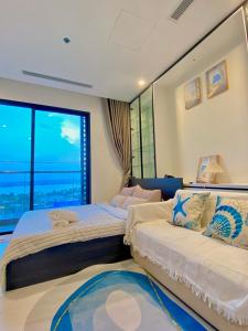 a bedroom with two beds and a large window at Căn hộ Master có sofa giường view sông Đồng Nai in Long Bình