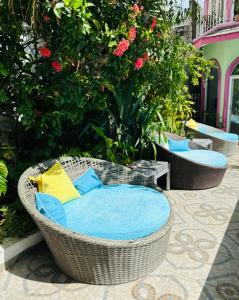 a wicker chair with blue and yellow pillows on a patio at The Quetzal in Cancún