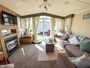 een woonkamer met een bank en een tv bij Lovely 8 Berth Caravan At California Cliffs, Near Scratby Beach Ref 50046L in Great Yarmouth