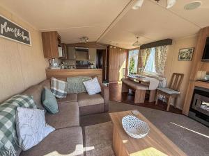 een woonkamer met een bank en een tafel bij Lovely 8 Berth Caravan At California Cliffs, Near Scratby Beach Ref 50046L in Great Yarmouth +10 foto's