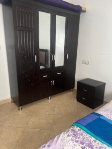 Oued LaouにあるIrmisのベッドルーム(ベッド1台、ドレッサー、テレビ付)