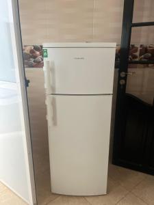 a white refrigerator in a kitchen next to a door at Irmis in Oued Laou