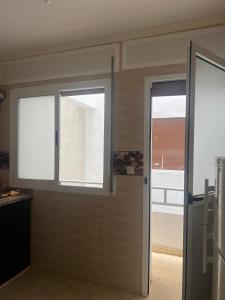 a kitchen with two windows and a door at Irmis in Oued Laou +25 photos