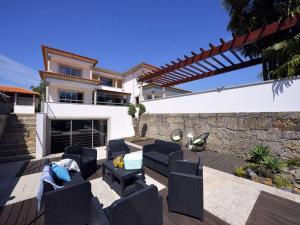 a patio with black furniture and a house at Tasteful Braga Villa 4 Bedrooms Villa Helena Private Pool & Close To Amenities Esposende in Esposende