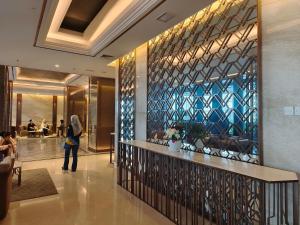 a woman standing in a lobby with a bar at Pollux Habibie Batam Polux in Batam Center +14 photos