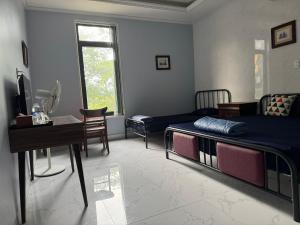 a bedroom with two beds and a desk and a table at Linh San Hotel in Thinh Làng +24 photos