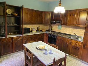 a kitchen with wooden cabinets and a table with food on it at Casa Lizluba in Montefegatesi