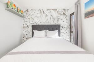 un letto bianco con due cuscini in una camera da letto di Casa Orillia de Mar - The Wharf 5F a Willemstad