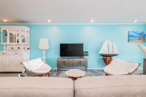 un soggiorno con divano, sedie e TV di Casa Orillia de Mar - The Wharf 5F a Willemstad