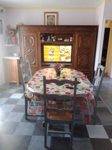 a dining room with a table and chairs and a tv at Maison complète in Montluçon