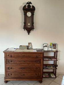 a wooden dresser with a clock on the wall at La Sofiètta in Borgo San Dalmazzo +19 photos
