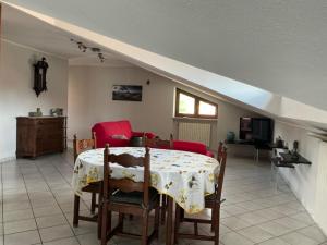 a dining room with a table and red chairs at La Sofiètta in Borgo San Dalmazzo