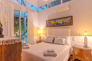 a bedroom with a white bed and a window at Beachfront Residencia Blanca in Puerto Viejo in Puerto Viejo