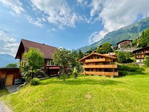 a person standing in a field in front of a building at Chalet Im Bätzenboden in Wengen