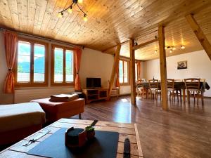 a living room with a table and a dining room at Chalet Im Bätzenboden in Wengen