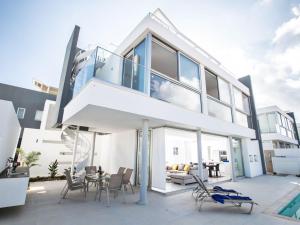 ein großes weißes Haus mit Glastüren und einer Terrasse in der Unterkunft Villa Panemorfi - Luxury Brand New 3 Bedroom Protaras Villa With Private Pool in Protaras