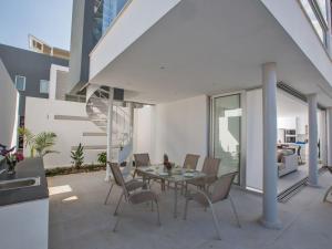 ein Esszimmer mit einem Tisch und Stühlen auf einer Terrasse in der Unterkunft Villa Panemorfi - Luxury Brand New 3 Bedroom Protaras Villa With Private Pool in Protaras