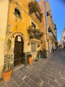 ein Gebäude mit einer Tür und Topfpflanzen auf einer Straße in der Unterkunft La Casa In Piazza in Marina di Camerota
