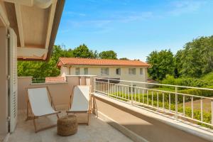 ein Balkon mit zwei Stühlen und einem Haus in der Unterkunft GOLDEN LUXE - Villa Golden next Twiga Beach Club in Marina di Pietrasanta + 37 Fotos