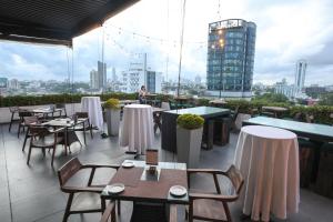 a restaurant with tables and chairs on the roof of a building at Best Western Elyon Colombo in Colombo