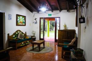 a living room with a couch and a table and a door at Casa de huéspedes la guarecita in Pátzcuaro