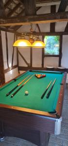 un tavolo da biliardo con palline e bastoncini di Maison Évasion Normande a Sainte-Opportune-la-Mare